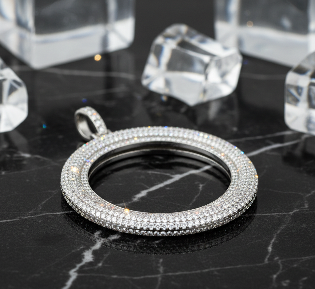 Silver pendant with clear stones on a dark surface with crystal-like objects in the background