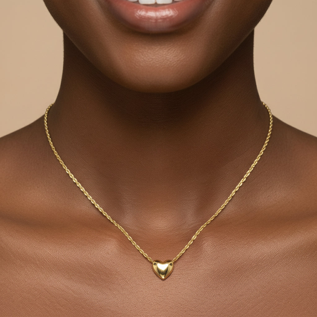 Gold heart-shaped pendant necklace on a white background
