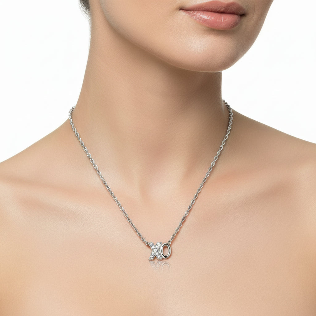 Silver necklace with a XO pendant on a white background